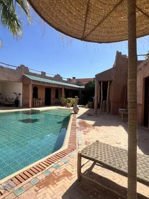 a swimming pool with a bench next to a house at Villa 4 chambres avec grande piscine privée in Marrakech