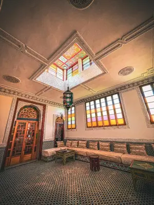 a room with a bench and stained glass windows at Dar Roots Fes Ziat in Fès