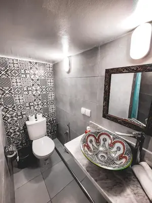 a bathroom with a sink and a toilet and a mirror at Dar Roots Fes Ziat in Fès