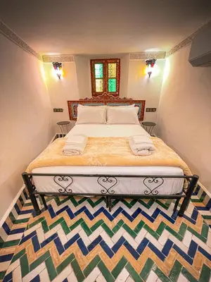 a bedroom with a large bed with two towels on it at Dar Roots Fes Ziat in Fès