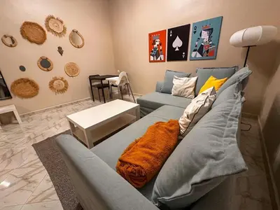 a living room with a blue couch with an orange blanket at Relax Family 05 - Cozy Entire Apartment in City Center in Ouarzazate
