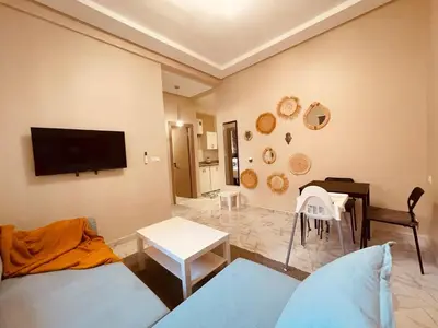 a living room with a couch and a tv on the wall at Relax Family 05 - Cozy Entire Apartment in City Center in Ouarzazate