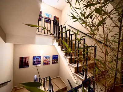 a spiral staircase with pictures on the walls and a plant at Relax Family 05 - Cozy Entire Apartment in City Center in Ouarzazate