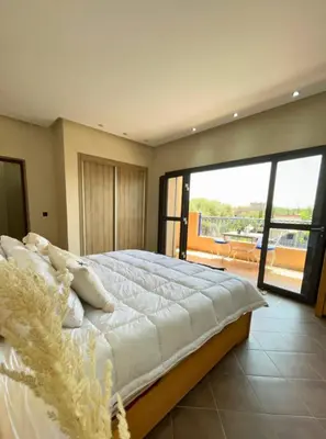 a bedroom with a large bed and a balcony at Shams Ourika in Sbiti