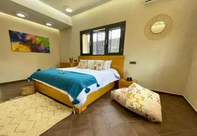 a bedroom with a large bed and a window at Shams Ourika in Sbiti