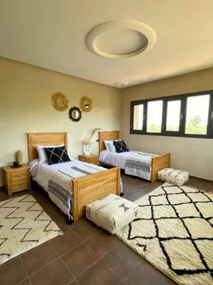 a bedroom with two beds and two rugs at Shams Ourika in Sbiti
