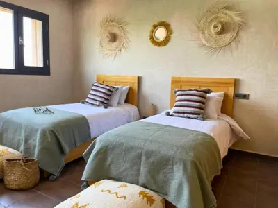 a bedroom with two beds and two mirrors on the wall at Shams Ourika in Sbiti