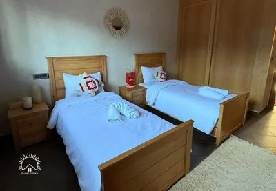 two beds in a hotel room with tworams at Shams Ourika in Sbiti