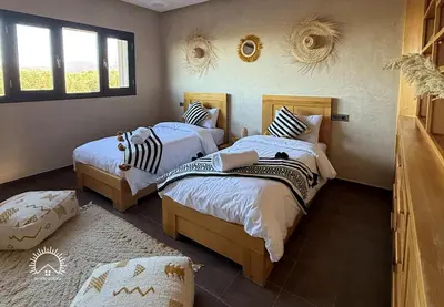 a bedroom with two beds in a room at Shams Ourika in Sbiti