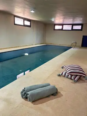 a swimming pool with two pillows on the floor at Shams Ourika in Sbiti