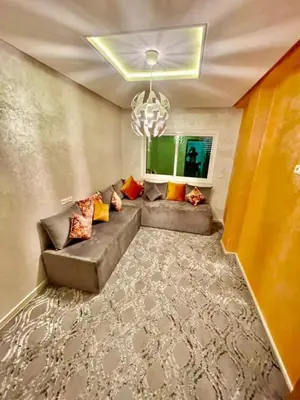a living room with a couch and a chandelier at Appartement de luxe à Tanger in Oulad Akkou