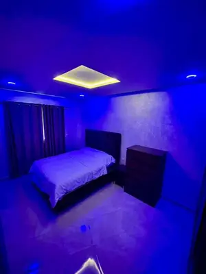 a bedroom with a bed and a blue light at Appartement de luxe à Tanger in Oulad Akkou