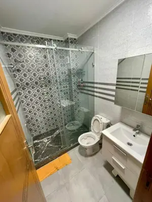 a bathroom with a shower and a toilet and a sink at Appartement de luxe à Tanger in Oulad Akkou