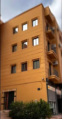 a tall building with windows on the side of it at Relax Family 04 - Cozy Entire Apartment in City Center in Ouarzazate