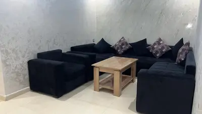 a living room with a blue couch and a table at arachidia in Beni Mellal