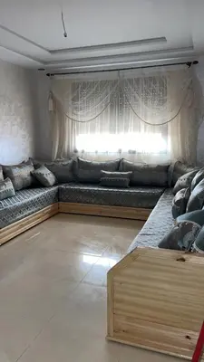 a living room with a long couch with a window at arachidia in Beni Mellal