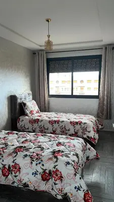 a bedroom with two beds and a window at arachidia in Beni Mellal