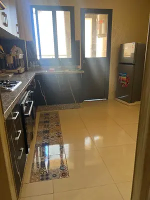 a kitchen with a refrigerator and a tile floor at arachidia in Beni Mellal