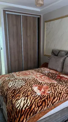 a bed in a room with a tiger print blanket at arachidia in Beni Mellal