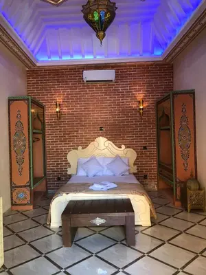 a bedroom with a bed and a brick wall at Eden Suites