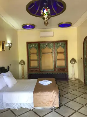 a bedroom with a large bed and a chandelier at Eden Suites