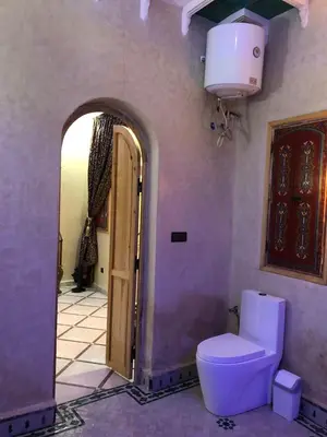 a bathroom with a toilet and an open door at Eden Suites