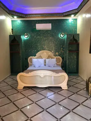 a bedroom with a bed with a green wall at Eden Suites