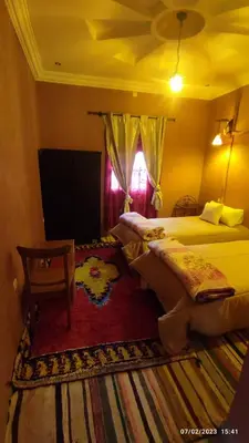 a bedroom with two beds and a window at Gite famille saghir in Skoura