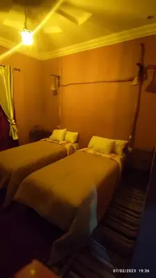 two beds sitting next to each other in a room at Gite famille saghir in Skoura