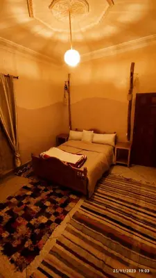 a bedroom with a bed in a room with a rug at Gite famille saghir in Skoura