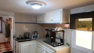 a kitchen with white cabinets and a window at Villa Dayet Roumi House in Friday Market