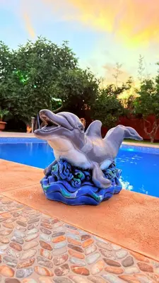 a dolphin statue sitting on a table next to a pool at Villa Dayet Roumi House in Friday Market