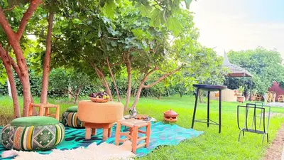 a picnic table and chairs on a blanket in the grass at Villa Dayet Roumi House in Friday Market