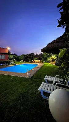 a backyard with a swimming pool and some lounge chairs at Villa Dayet Roumi House in Friday Market