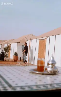 a man is standing inside of a tent at Aisha VIP Camp in Merzouga