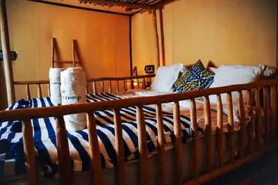 a bedroom with a bed with a wooden rail at Aisha VIP Camp in Merzouga