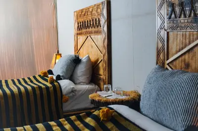a room with a couch and a chair with a table at Aisha VIP Camp in Merzouga