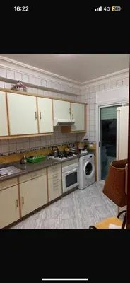 a kitchen with a stove and a microwave at residence le litoral 1 in Oulad Akkou