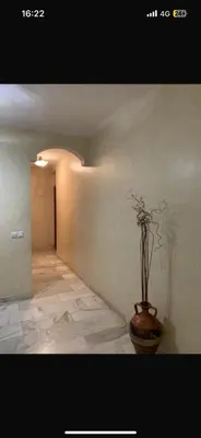 a hallway with a vase with flowers in it at residence le litoral 1 in Oulad Akkou
