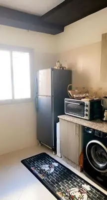 a kitchen with a refrigerator and a microwave at Appartement exceptionnel a louer in Oulad Akkou