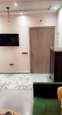 a living room with a door and a green couch at Appartement exceptionnel a louer in Oulad Akkou