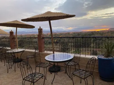 a patio with tables and chairs and umbrellas at Maison d'hôte IGRANE in Tinerhir