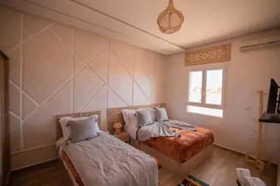 a bedroom with two beds and a window at Maison d'hôte IGRANE in Tinerhir