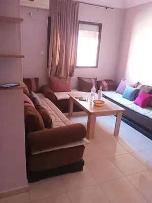 a living room with a couch and a table at Apparemment en résidence à 10 mns de Gueliz in Oulad Akkou