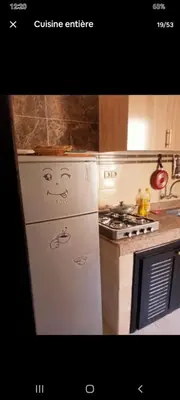 a kitchen with a refrigerator with a face drawn on it at Apparemment en résidence à 10 mns de Gueliz in Oulad Akkou