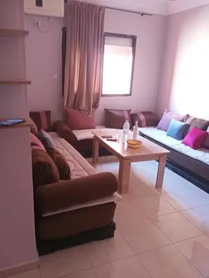 a living room with a couch and a table at Apparemment en résidence à 10 mns de Gueliz in Oulad Akkou