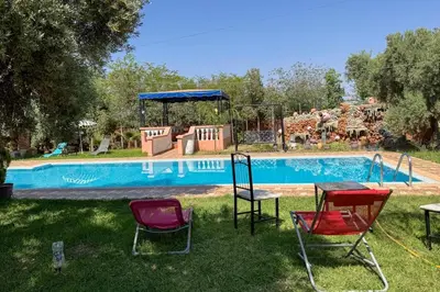 a group of chairs in front of a swimming pool at Villa Jenane Rabia in Amezrou