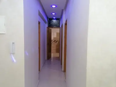 a hallway with purple walls and a television on a wall at Aicha's appartement 1 in Meknès