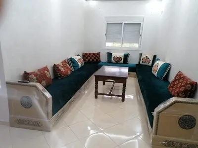 a living room with a green couch and a table at Aicha's appartement 1 in Meknès
