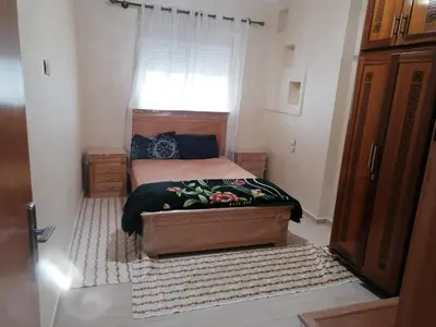 a small bedroom with a bed and a window at Aicha's appartement 1 in Meknès